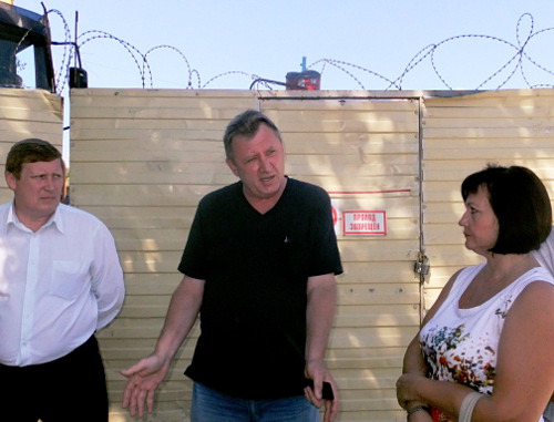 Заместитель главного инженера ЗАО «ПРиСС» Владимир Василенко (в центре) поясняет заместителю руководителя государственного казенного учреждения «Главное управление строительства Краснодарского края» Андрею Хромых и члену домового комитета улицы Конституции и Юных Ленинцев Вере Гурьяновой, что прекратить ночные работы невозможно из-за особенностей технологии. Сочи, 20 июля 2012 г. Фото Светланы Кравченко для "Кавказского узла"