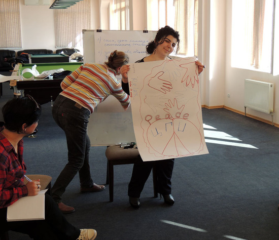 Марта показывает наработки их группы на плакате. Марта показывает наработки их группы на плакате.