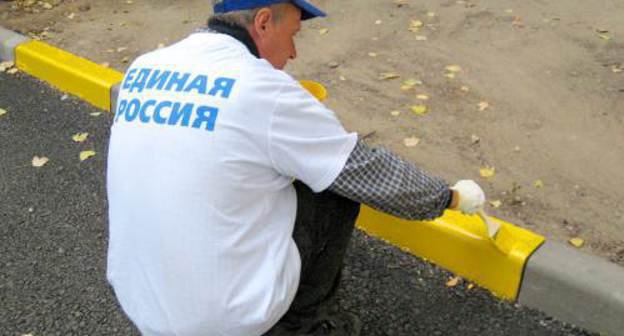 Участник акции "Новые дворы Единой России" красит бордюры во дворе дома №60 по ул. Коммунистической в Ленинском районе г. Астрахани. 13 октября 2011 г. Фото Вячеслава Ященко для "Кавказского узла"