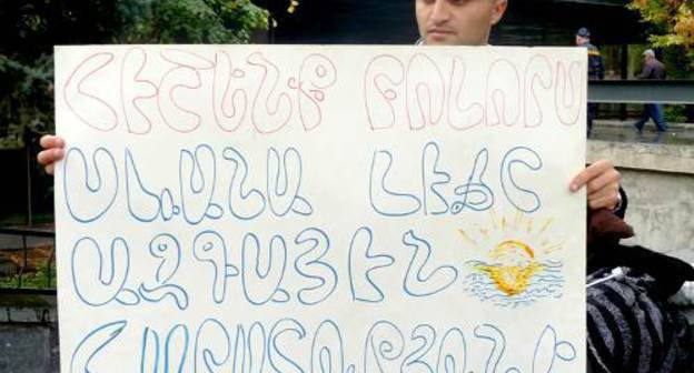 Участник акции протеста "SOS Sevan" держит плакате ''Давайте не забудем, что озеро Севан - национальное достояние''. Армения, Ереван, 19 октября 2011 г. Фото Армине Мартиросян для "Кавказского узла"