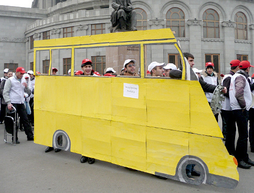 Участники флеш-моба с макетом микроавтобуса имитируют езду в переполненных маршрутных такси. Ереван, Армения, 16 декабря 2011 г. Фото Армине Мартиросян для "Кавказского узла"
