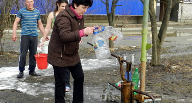 Жители поселка Удобного набирают воду из колонки. Адыгея, март 2012 г. Фото Леонида Мертца