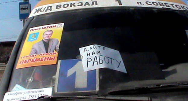 Маршрутное такси с лозунгом бастующих и предвыборным плакатом Олега Шеина. Астрахань, 13 апреля 2012 г. Фото Елены Гребенюк для "Кавказского узла"