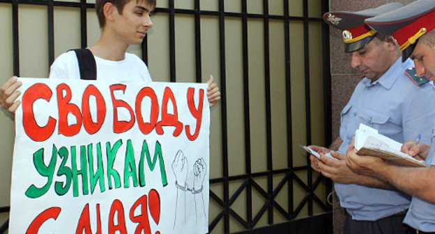 Краснодар, 26 июля 2012 г. Пикет в защиту задержанных по делу о беспорядках на Болотной площади. Сотрудники полиции переписывают паспортные данные участника пикета, активиста партии "Яблоко" Игоря Харченко. Фото Никиты Серебрянникова для "Кавказского узла"