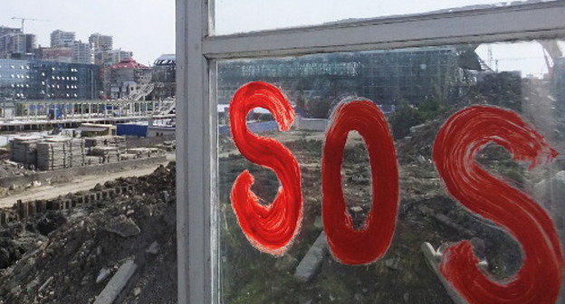 Надпись "SOS" на окне дома №65 по улице Просвещения, замурованного строителями МПО "Мостовик", чтобы добиться выселения жильцов. Сочи, октябрь 2012 г. Фото Светланы Кравченко для "Кавказского узла"