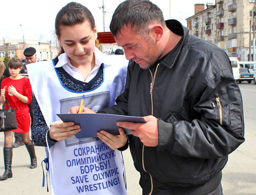 Флеш-моб за сохранение борьбы как олимпийского вида спорта прошел возле кинотеатра "Дружба". На снимке: волонтер собирает подписи. Владикавказ, 15 марта 2013 г. Фото Эммы Марзоевой для "Кавказского узла" Флеш-моб за сохранение борьбы как олимпийского вида спорта прошел возле кинотеатра "Дружба". На снимке: волонтер собирает подписи. Владикавказ, 15 марта 2013 г. Фото Эммы Марзоевой для "Кавказского узла"