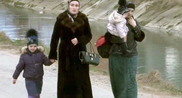 Женщины и дети выходят из зоны КТО. Махачкала, поселок Семендер, 20 марта 2013 г. Кадр из видеосъемки с сайта МВД Дагестана, http://05.mvd.ru