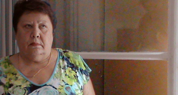 Cторож детского сада "Ган Геула" Галина Балахонова у окна, разбитого вандалами. Волгоград, 27 августа 2013 г. Фото Вячеслава Ященко для "Кавказского узла"