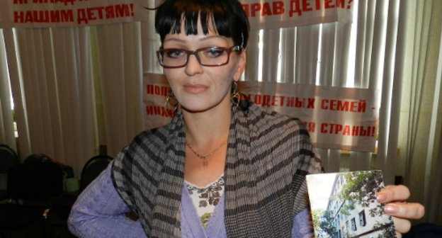 Участница голодовки многодетных родителей Марина Чернова показывает фото полуразрушенного общежития, где она живет с семерыми детьми. Волгоград, 26 сентября 2013 г. Фото Татьяны Филимоновой для "Кавказского узла"