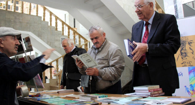 Махачкала, Национальная библиотека, вторая дагестанская книжная ярмарка "Тарки-Тау". Посетители у стенда культурно-общественной организации "Богос". 10 октября 2013 г. Фото Махача Ахмедова для "Кавказского узла"
