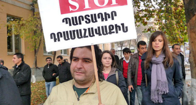 Участники акции протеста потребовали от властей Армении доработать реформу пенсионной системы. На снимке: один из участников акции с плакатом "STOP обязательным сборам". Ереван, 15 ноября 2013 г. Фото Армине Мартиросян для "Кавказского узла"