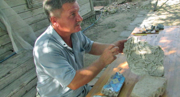 Астраханский археолог Евгений Пигарев показывает золотоордынские изразцы, середина XIV века, обнаруженные во время раскопок Селитренного городища. Астраханская область, сентябрь 2014 г. Фото Вячеслава Ященко для "Кавказского узла"