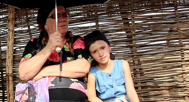 Девочка и её бабушка ожидают автобус на остановке, июль 2014, Чечня. Фото Магомеда Магомедова для "Кавказского узла"