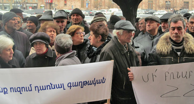 Акция бывших сотрудников завода "Наирит". Надписи на транспарантах: «Мы не хотим стать эмигрантами» (слева), «Не терзайте законы Республики Армении!» (справа). Ереван, 5 марта 2015 г. Фото Тиграна Петросяна для "Кавказского узла"