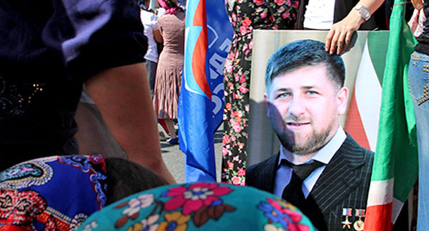 Участница митинга в честь празднования дня Республики в Чечне держит в руках портрет Рамзана Кадырова. Грозный, 6 сентября 2015 г. Фото Магомеда Магомедова для "Кавказского узла"