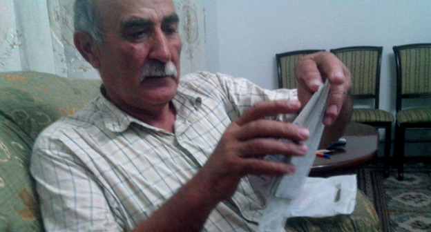 Мирзамагомед Лукманов показывает свои документы и квитанции об оплате. Фото Аиды Гаджиевой для "Кавказского узла"