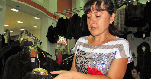 Представитель предпринимательницы Наталья Клочкова в торговом центре показывает поврежденный мех на шубах. Астрахань, 19 июля 2015 г. Фото Вячеслава Ященко для "Кавказского узла"