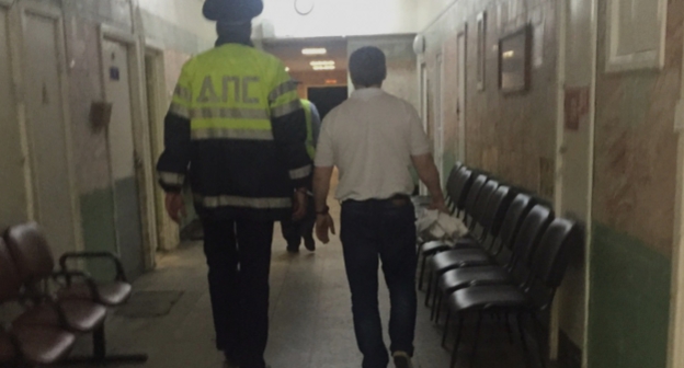 Хаджимурада Темурзиева ведут в зал суда. Москва, 28 августа 2015 года. Фото Микаила Костоева