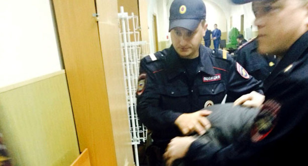 Сотрудники правоохранительных органов ведут одного из фигурантов дела об убийстве Немцова по коридору суда. Москва, 23 апреля 2015 г. Фото Юлии Буславской для "Кавказского узла"