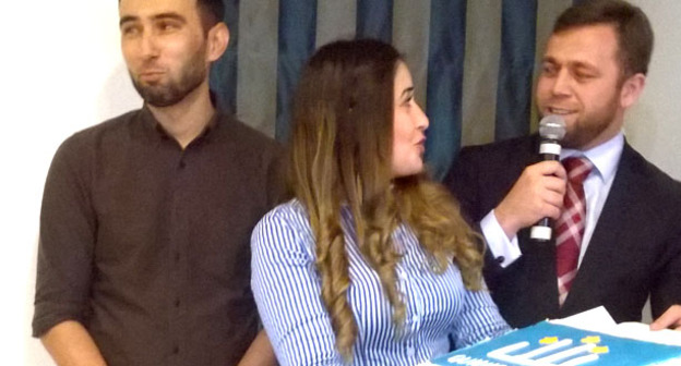 Автору выставки Рашиду Каирбекову (слева) вручают торт с гербом кумыкской организации "Qumuqlar". Справа -  продюсер мероприятия, лидер Московской кумыкской организации Qumuqlar Рамазан Алпаут. Москва, 29 сентября 2015 г. Фото Вячеслава Ферапошкина для "Кавказского узла"