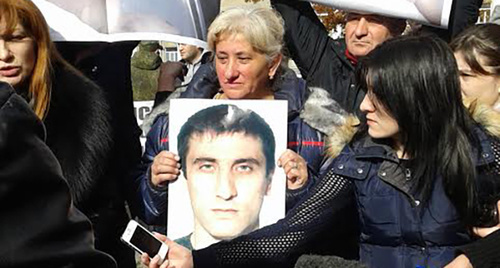 Женщина держит фото погибшего на митинге. Фото Эммы Марзоевой для "Кавказского узла"