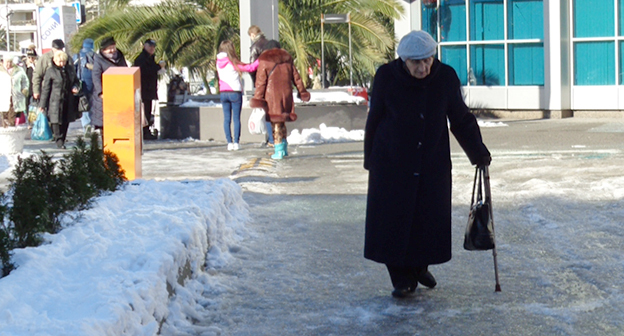 Пожилая женщина на скользкой дороге. Фото Светланы Кравченко для "Кавказского узла"