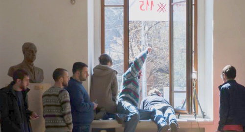 Запершиеся в аудитории № 115 студенты ТГУ общаются с людьми на улице через окно. Фото: RFE/RL