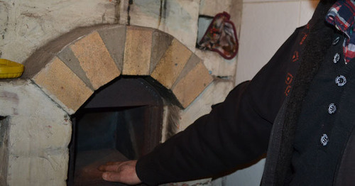 Николай Яковенко показывает печь, откуда в отсутствии хозяев неизвестный полицейский извлек наркотик. Фото Светланы Кравченко для "Кавказского узла"