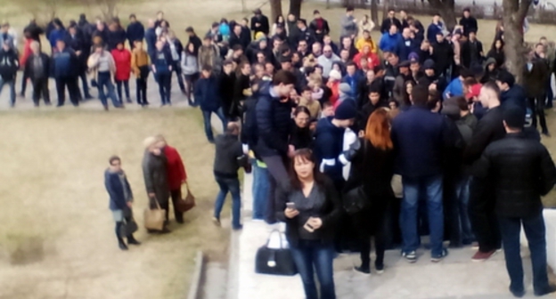 Сторонники Навального в Астрахани ждут, пока один из них завершит одиночный пикет, чтобы затем поочередно выходить на аналогичные пикеты. 26 марта 2017 года. Фото Елены Гребенюк для "Кавказского узла".