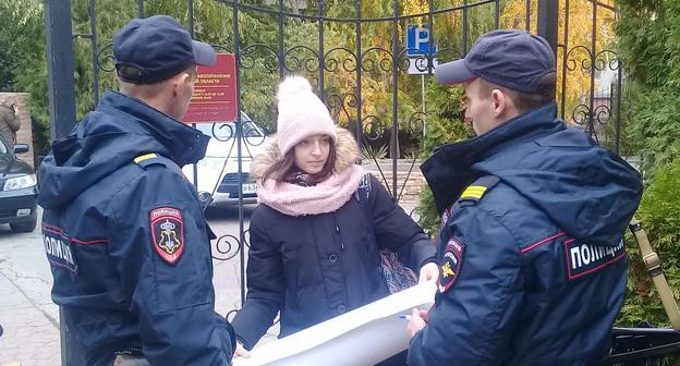 В ходе пикета двое полицейских проверили документы у Веры Иноземцевой. Астрахань, 25 октября 2017 года. Фото Елены Гребенюк для "Кавказского узла".


