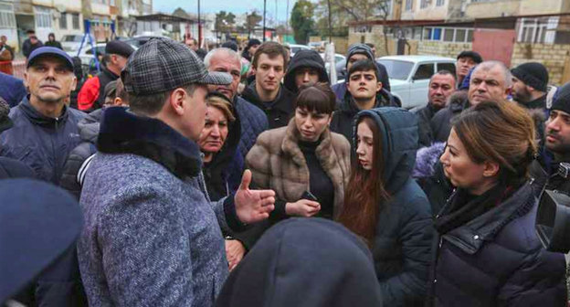Артём Здунов (слева) и жильцы горящего дома в Дербенте 03.01.2019. Фото http://e-dag.ru/novosti/novosti-pravitelstva/artjom-zdunov-provel-operativnoe-soveshchanie-v-svyazi-s-chs-v-g-derbente.html#!prettyPhoto[gallery647feb54ba]/5/

