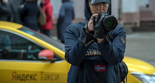 Фотограф у автомобиля Яндекс.Такси". Фото Нины Тумановой для "Кавказского узла"