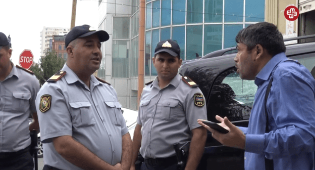 Журналист Тезехан Мираламли спорит с полицейскими, 11 сентября 2019 года. Скриншот видео https://www.facebook.com/MeydanTelevision/videos/671447066668670/?v=671447066668670