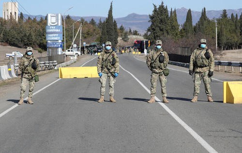 Грузинские военнослужащие в защитных масках на посту  в Марнеули близ Тбилиси, Грузия. Фото:иREUTERS/Irakli Gedenidze/