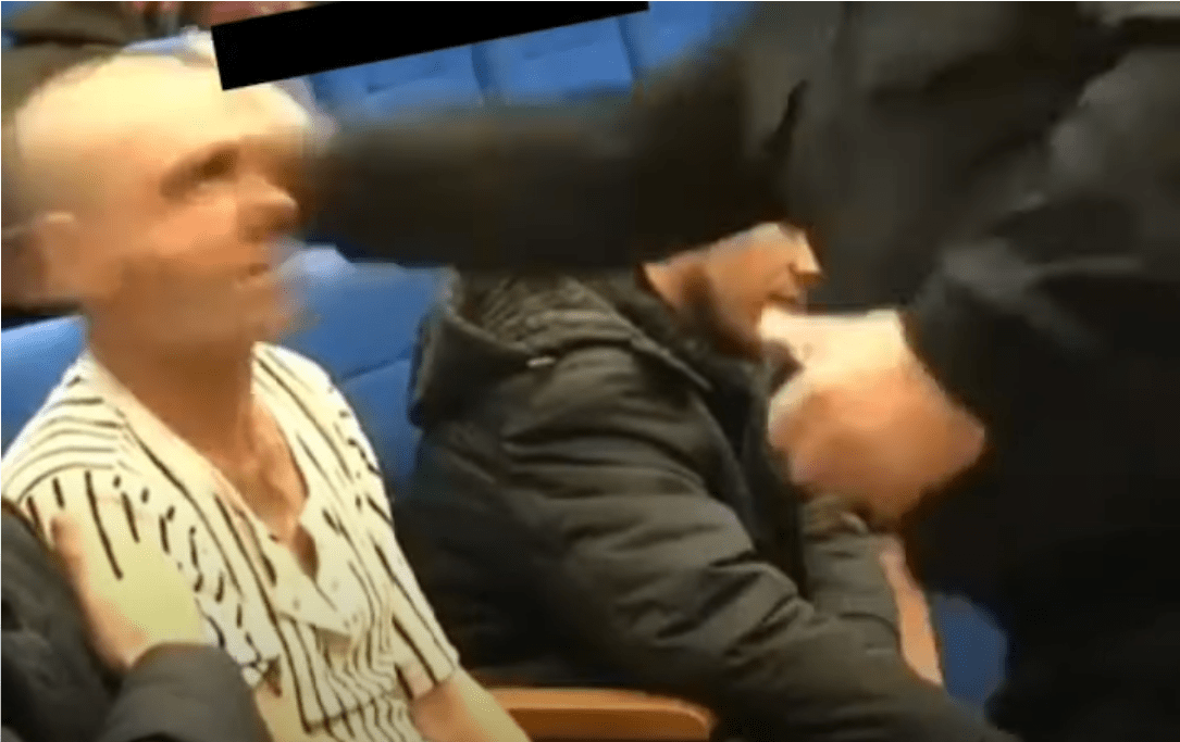 Абушайх Висмурадов (стоит справа) наносит удар старику. Стоп-кадр видео "Абу Шейх Висмурадов ударил чеченского старика", https://www.youtube.com/watch?v=1wSv_LEFN10