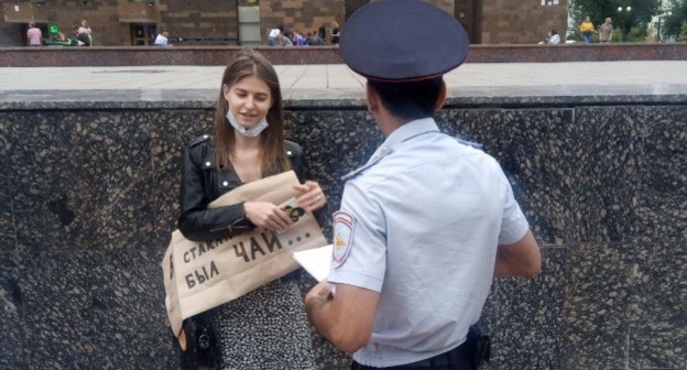 Полицейский проверяет документы у активистки Юлии Ляшовой. Фото: Валерий Люгаев для "Кавказского узла"

