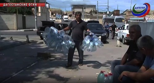 Жители Дагестанских огней с пластиковыми бутылками для питьевой воды. Иллюстративное фото. Скриншот видео https://www.rgvktv.ru/obshchestvo/60898