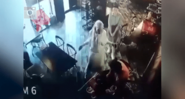 Конфликт между Элезом Мержоевым (в оранжевой одежде) и Айной Гетагазовой (в белом) в назранском кафе 15 июня 2021 года. Стоп-кадр видео https://dni.ru/video/2021/6/17/481045.html