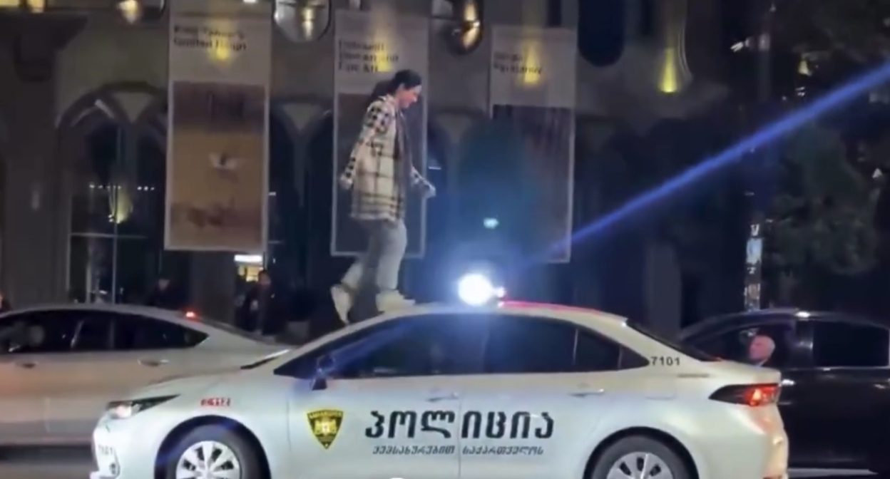 Тамар Лорткипанидзе на крыше полицейской машины. Кадр видео News.On.ge