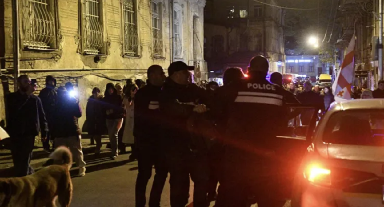 Силовики задерживают участников шествия. Скриншот фото "Интерпрессньюс" от 22.11.25, https://www.interpressnews.ge/ka/article/855324-parlamenttan-shekrebilebi-msvlelobas-martaven-ingoroqvas-kuchastan-akciis-kidev-ramdenime-monacile-daakaves