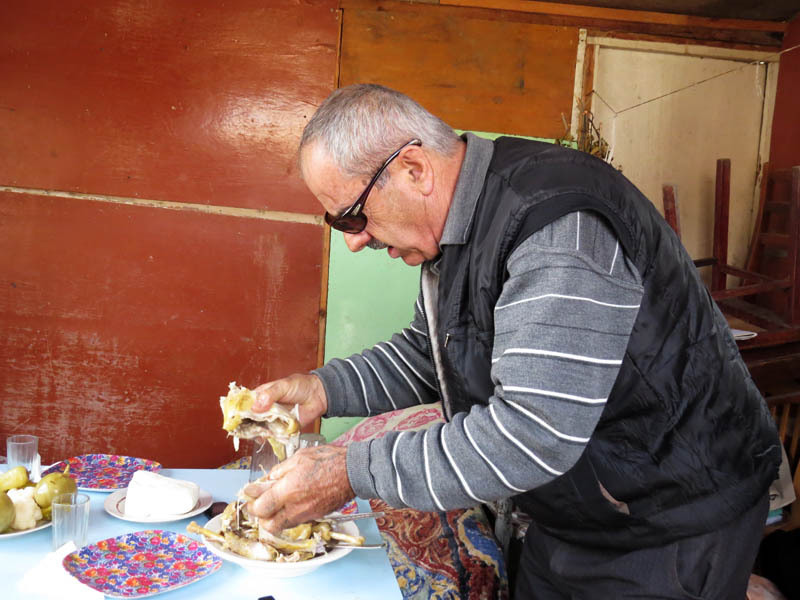 Лёва разбирает варёную курицу на куски.